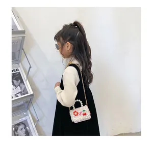 Détail du sac à main rose tressé pour fille avec perles, cerises et une chaîne dorée