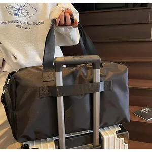 Detalle de la banda para maleta de un bolso de gimnasia negro en un equipaje blanco