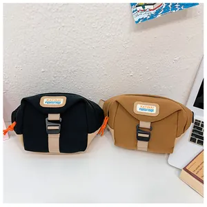 Detail of canvas waist bags in black and brown patchwork with orange drawstrings