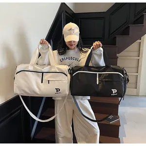 Detalle del bolso de viaje con asas reforzadas y un práctico bolsillo lateral con cremallera
