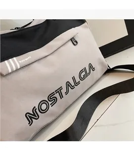 Detail of soft canvas travel bag featuring letters and signature contrast stripes