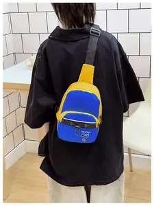 Detail view of the blue and yellow cross-body bag with adjustable strap worn by model