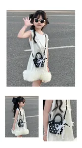 Detail of girls mini polka dot crossbody bag with lace bow and pearl handle on child model