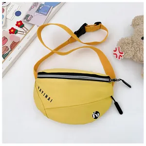 Detail van gele crossbodytas voor kinderen met zwarte rits en verstelbare nylon riem