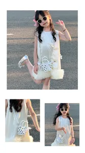 Detail of girls' beige sleeveless dress with bow and matching polka dot bucket bag