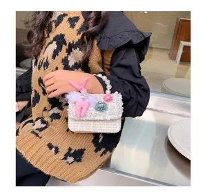 Détail du mini sac en tweed avec poignée en perles et breloque lapin pour fillettes