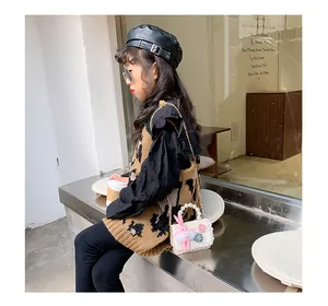 Jeune fille à la mode portant un sac à main blanc pailleté avec poignée perle et lapin rose