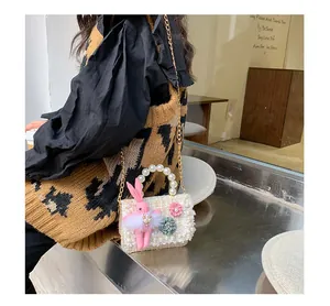 Détail du mini sac blanc texturé avec poignée en perles et décor de lapin en peluche