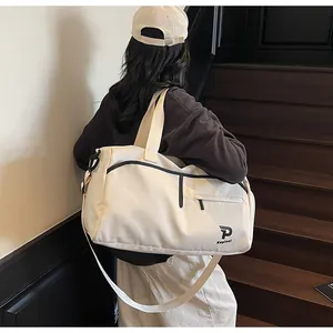 Detalle del logo Kayinel en bolsa de viaje blanco crema con cremallera negra