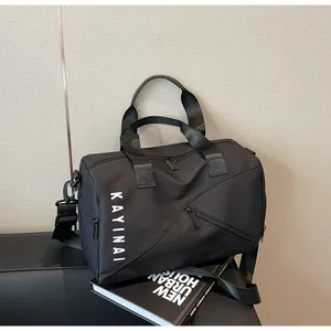 Detalle de una bolsa de deporte negra con compartimentos amplios y correa de hombro extraíble