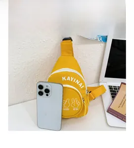 Detail of yellow canvas mini chest bag for kids featuring a smartphone for size reference