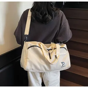 Vista trasera de una modelo llevando el gran bolso de yoga crema en una escalera mínima
