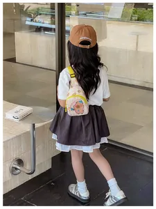 Détail du sac de poitrine pour enfant à damier crème avec sangle jaune et capybara