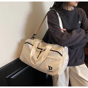 Detalle del bolso de yoga crema con correas negras y logo P Kayinal en tejido duradero