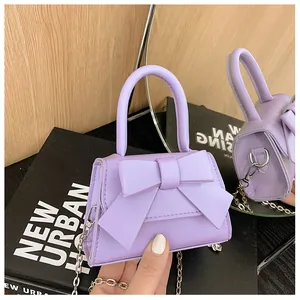 Detail van lavendel mini-tasje met een grote strik en metalen ketting schouderriem
