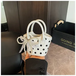 Detail of mini polka dot handbag with pearl bow charm and lace trim for girls