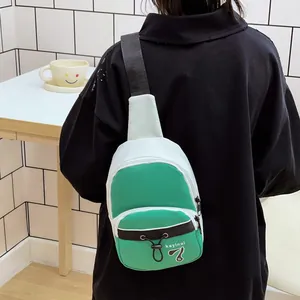 Mini crossbody chest bag in green and white nylon with adjustable wide black shoulder strap