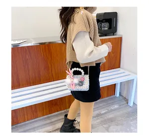 Détail du sac bandoulière en tweed bleu clair avec anse perle et breloque lapin