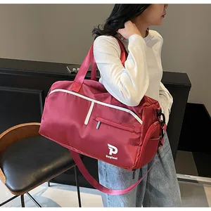 Vista lateral de un gran bolso deportivo granate llevado por una modelo en un interior