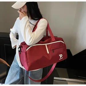 Detalle de bolsa de deporte roja con correa ajustable y bolsillo lateral en tela impermeable