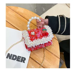 Détail du mini sac enfant en tweed rouge avec poignée perle et breloque fleur