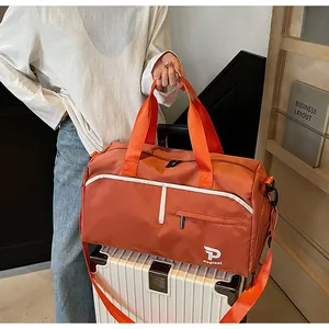 Detalle del bolso de viaje naranja impermeable sobre el asa de una maleta blanca