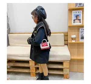 Détail du sac à main rouge en tweed pour fille avec anse en perles et chaîne dorée