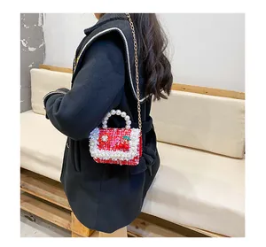 Détail du sac fille en tweed rouge avec anse en perles, cerise et bord en dentelle