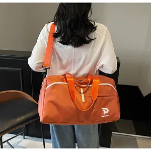 Detalle de una bolsa de deporte naranja con estampados blancos y asas resistentes