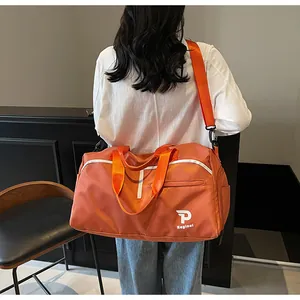 Detalle de la bolsa de deporte naranja con correa ajustable y bolsillo lateral con cremallera