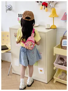 Bébé portant un sac bandoulière rose avec oursons sur un t-shirt jaune vif pour enfant