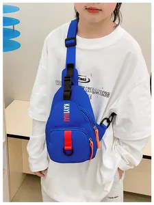 Detail of royal blue kids crossbody bag with orange zippers and red webbing straps