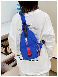 Detail of royal blue kids crossbody bag with orange zippers and adjustable strap on model