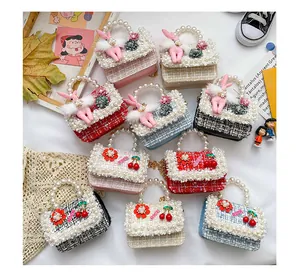 Détail de mini sacs en tweed avec poignées en perles et breloques lapin en peluche
