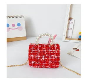 Détail du mini sac en tweed rouge avec poignée en perles et bandoulière chaîne dorée