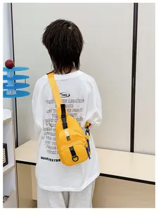 Detailed back view of a yellow nylon kids chest bag with adjustable black strap and logo