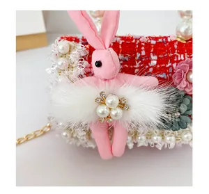 Détail d'un sac lapin en tweed avec poignées en perles et bordure en dentelle