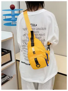 Boy wearing bright yellow nylon crossbody bag with blue zipper detail and white lettering