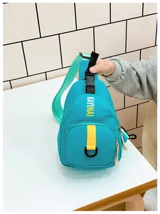 Detail of teal nylon kids crossbody bag featuring yellow straps and KAYINAI lettering