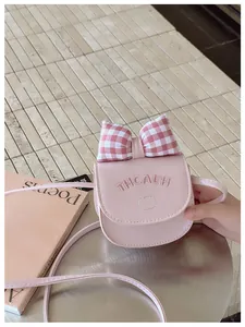 Pink mini crossbody bag featuring cat embroidery, a large checkered bow, and PU leather