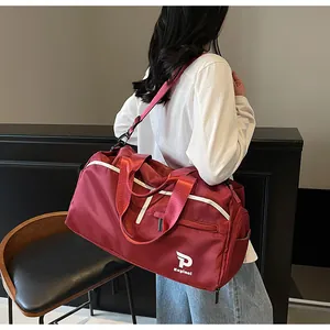Bolso deportivo burdeos grande con correa y logo blanco mostrado en la espalda