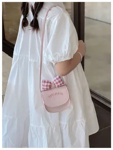 Detail of pink child crossbody bag with red checkered bow and alphabet logo