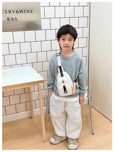 Kids stylish canvas chest bag in cream with orange zipper and black KAYNAI lettering
