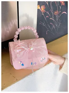 Detail of pink lace handbag with pearl beaded handle and oversized mesh bow decoration