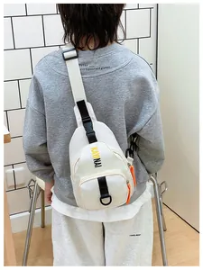 Detail view of cream crossbody bag featuring letter print and orange zipper pulls