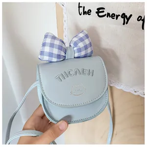 Close-up of light blue kids crossbody bag with blue bow and cat embroidery detail