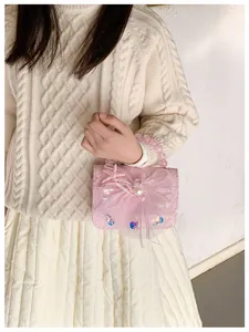 Close-up of pink lace handbag featuring a mesh bow, starfish charm, and pearl bead handle