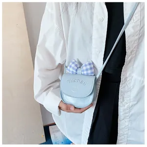 Close-up of mini blue PU leather crossbody bag featuring checkered bow and cat motif