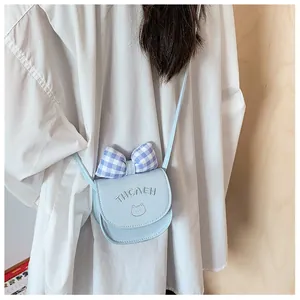 Close-up of a mini light blue crossbody bag with a checkered bow and cat pattern