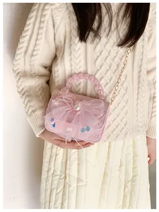 Detail of pink lace girl's handbag with large mesh bow, pearl and sequin accents